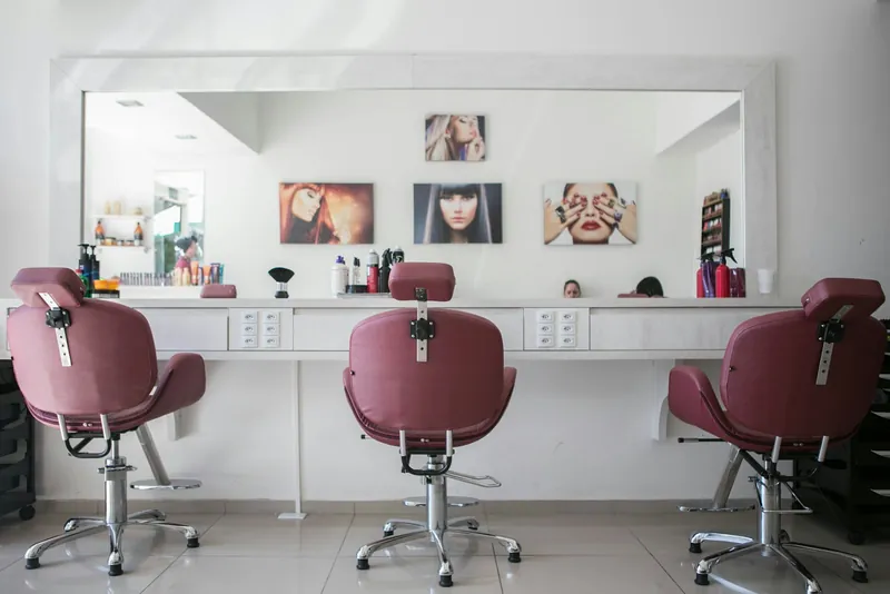 A stylist blow drying a client's hair with a round brush