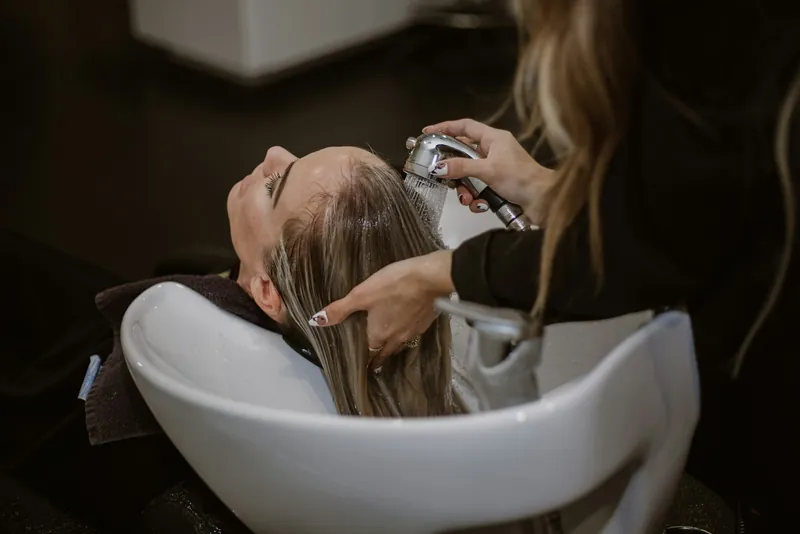 A client's hair being washed and treated at the basin
